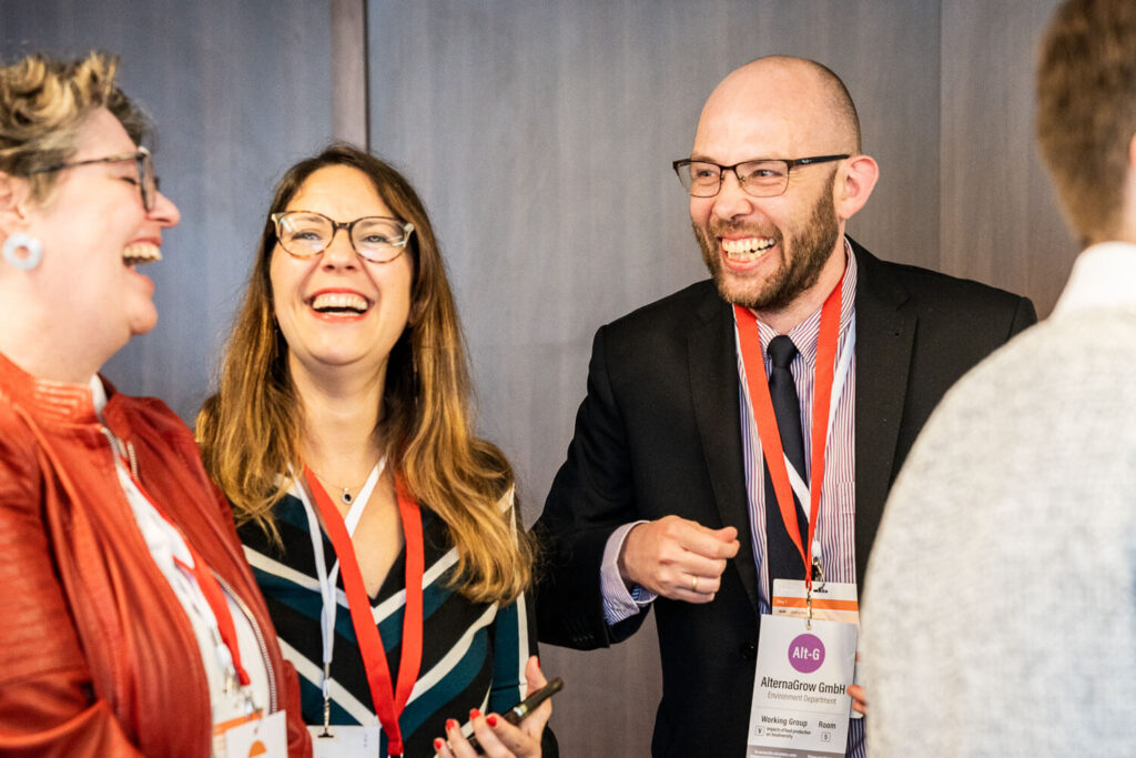 3 person talking and laughing at a conference