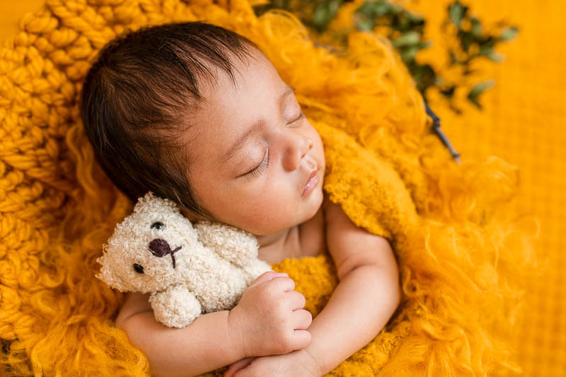 sleeping baby with mustard-yellow background